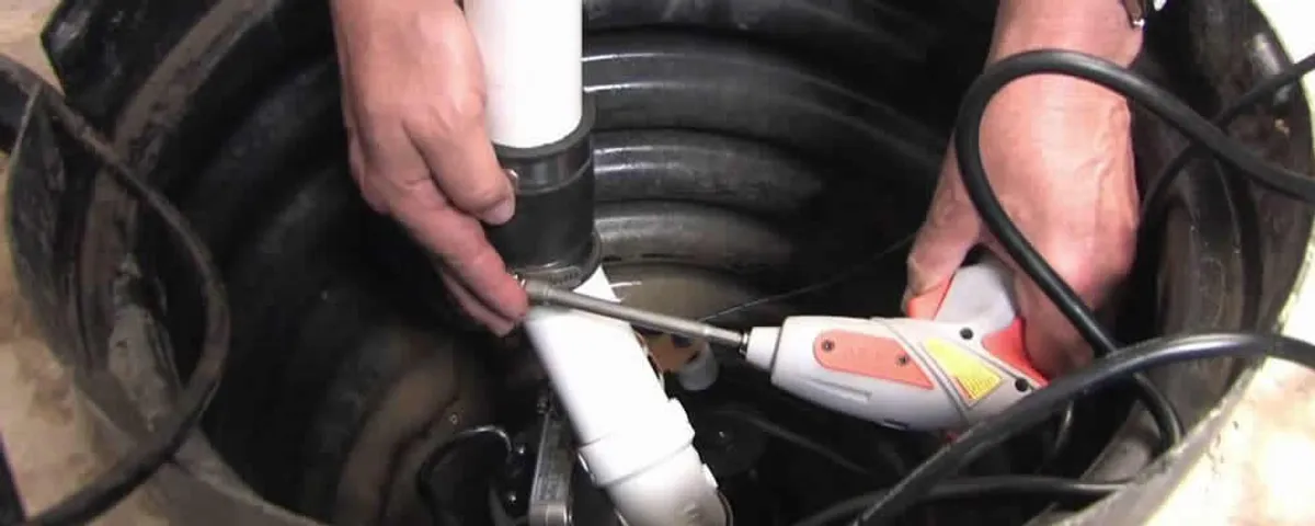 Sump pump installation technician connecting PVC discharge piping in Overland Park, KS